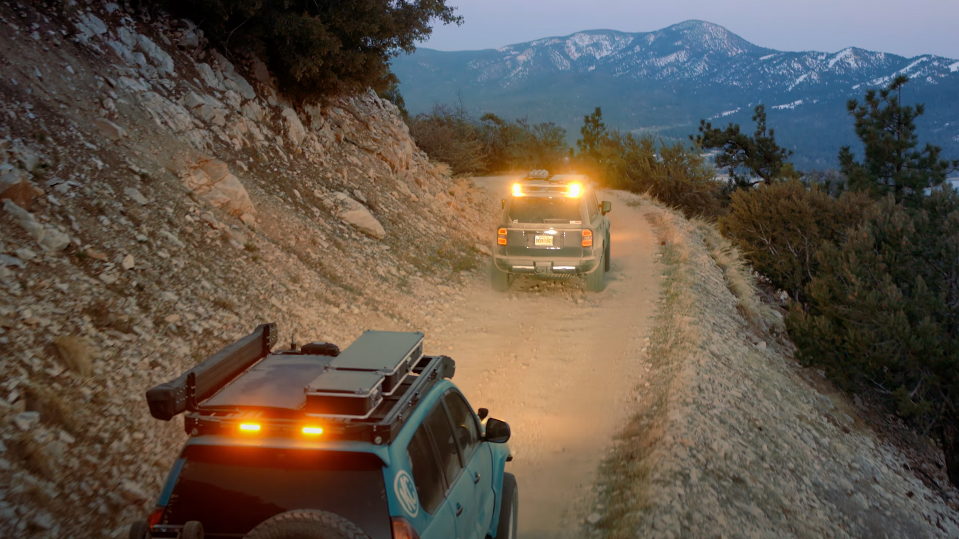 Overland trucks with yellow dust lights.